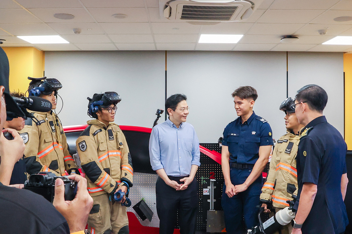 SGT1 (NSF) Heng Jin Xin, Section Commander, Punggol Fire Station (third from right), briefing PM Wong on the Smart Classroom and its Extended Reality training systems.