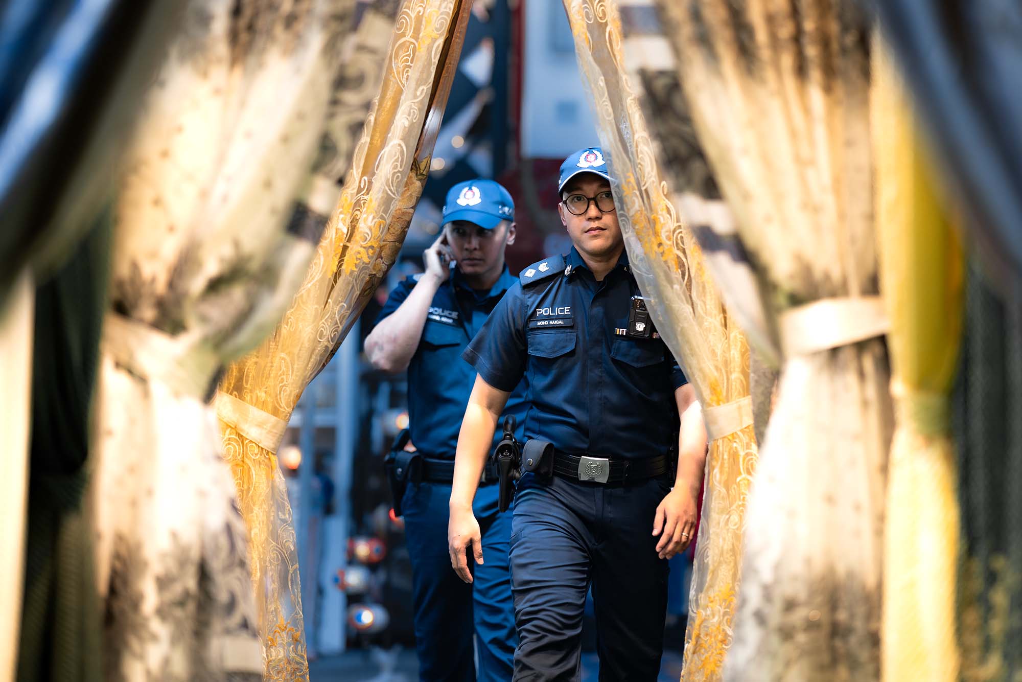 Drawing back the curtain: DSP (NS) Haiqal and Sgt (NS) Haikel weave through the shops while on patrol in the day.