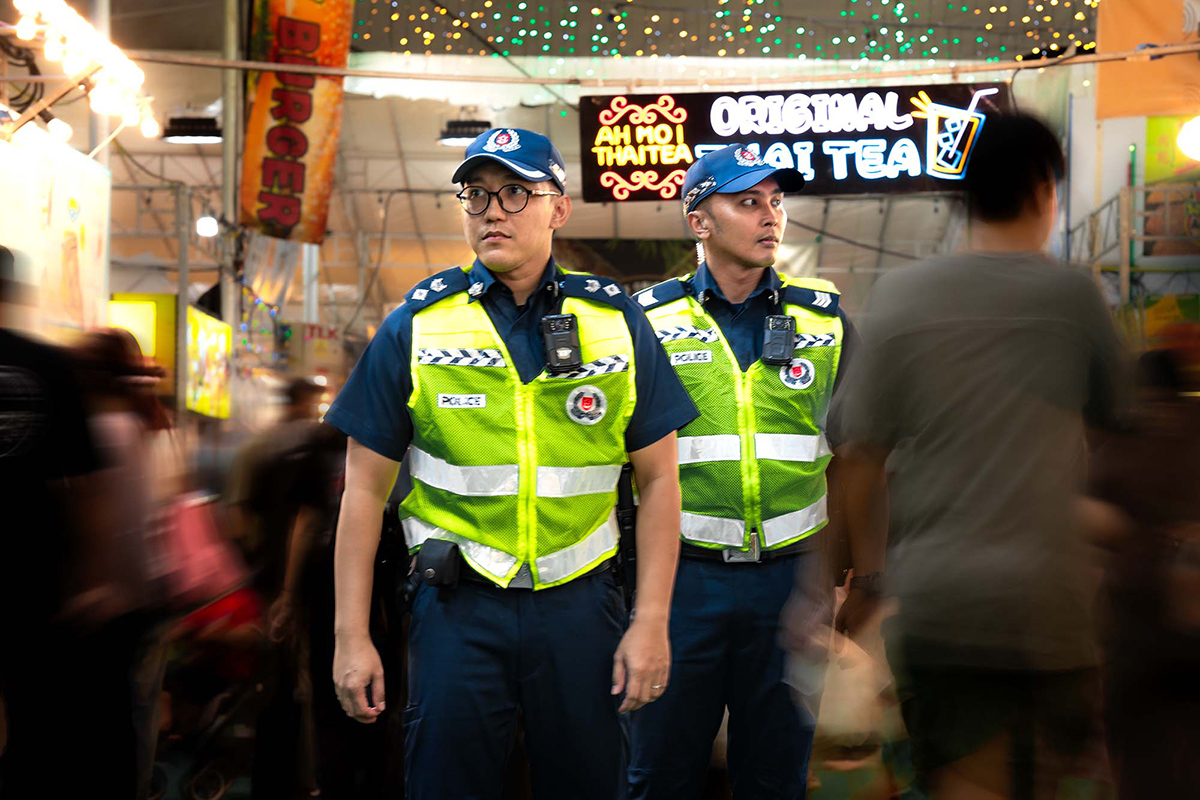 DSP (NS) Haiqal and Sgt (NS) Haikel patrolling in their Police vests during the night when the bazaar crowd was at its peak.