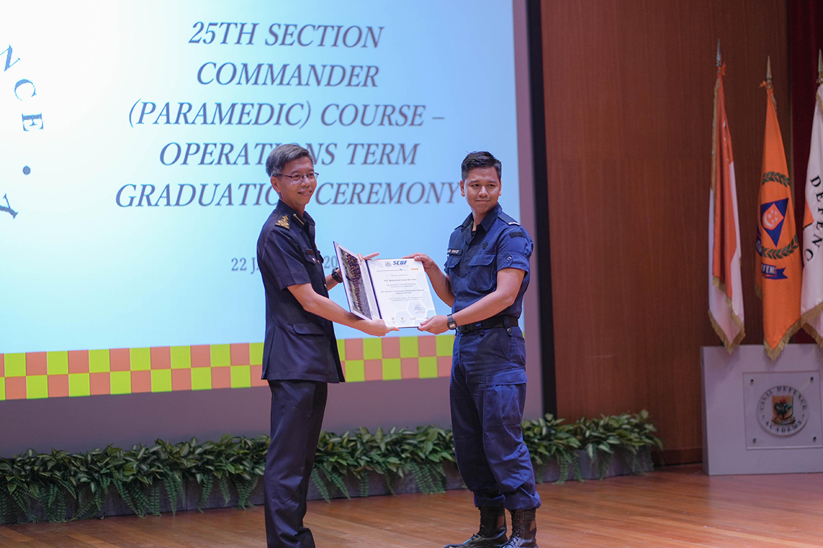 Director of Emergency Medical Services Department, SAC Yong Meng Wah (left) presenting the graduation certificate to Anaqy (right) upon his completion of the Section Commander (Paramedic) Course.